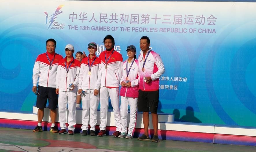 我校学生袁茹蓓(中)、张东霜(左)、李懿昕(右),与她们的教练在领奖台上