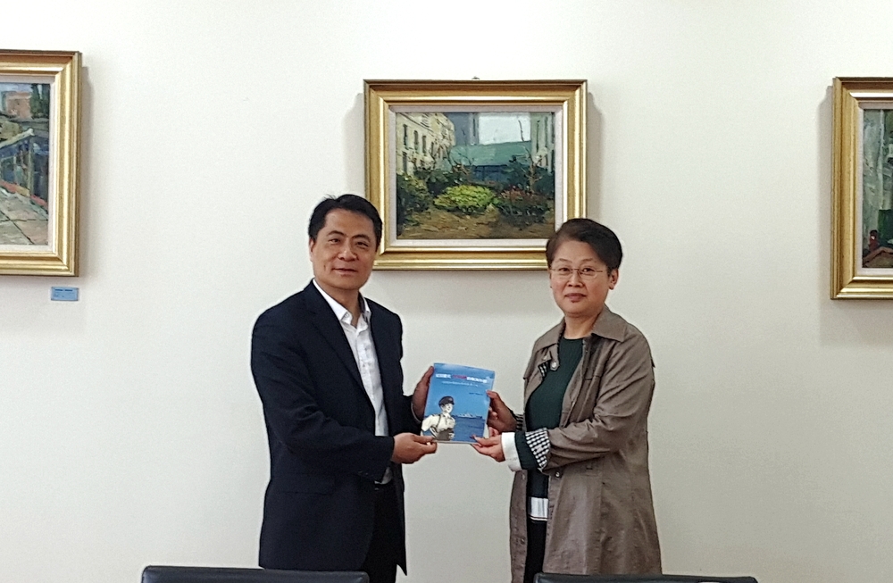 门妍萍副书记向王煜副馆长赠送我校校史系列图书