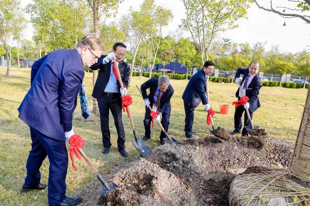 在体育馆日晷旁参与植树活动