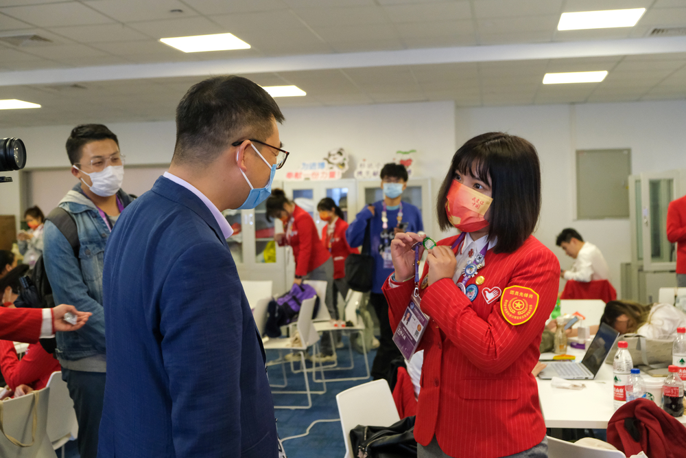 20211109103005621300.jpg 志愿者向李志鹏副校长介绍徽章文化