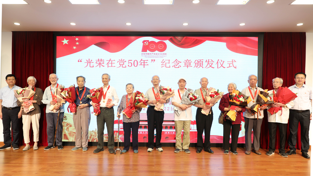 校领导为退休党员颁发纪念章、献花并合影留念