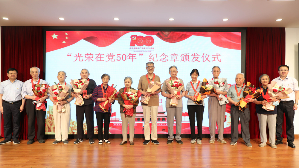 校领导为退休党员颁发纪念章、献花并合影留念