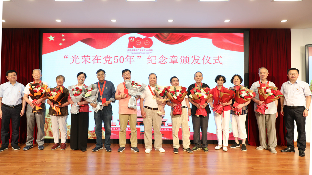 校领导为退休党员颁发纪念章、献花并合影留念