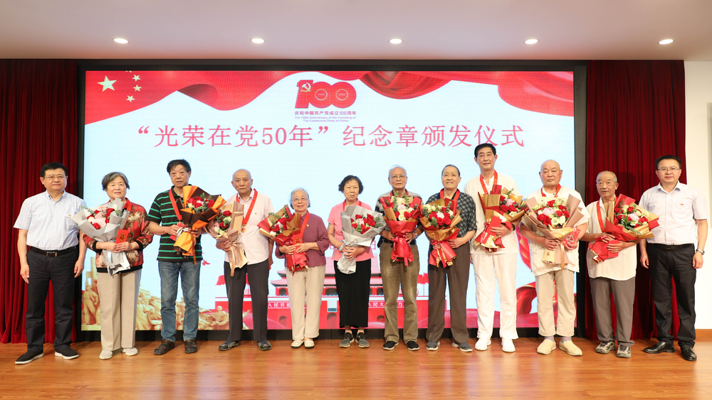 校领导为退休党员颁发纪念章、献花并合影留念