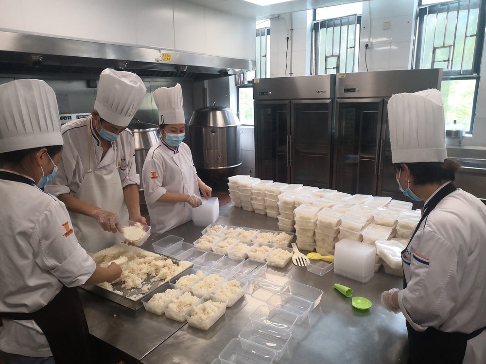 食堂工作人员将饭菜分装