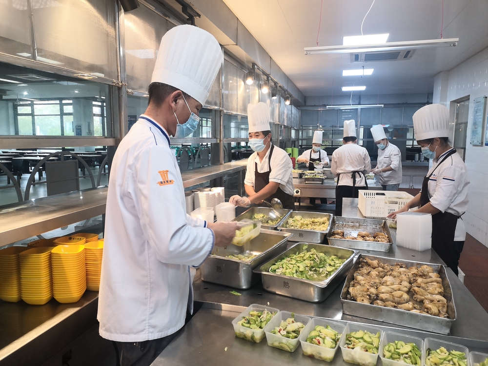 食堂工作人员将饭菜分装