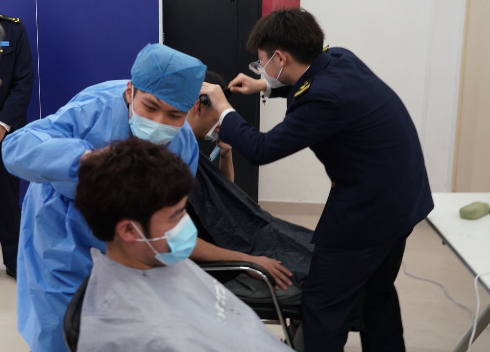 临港校区学生“理发师”志愿者们正在为同学理发