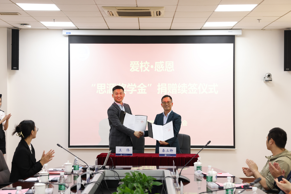 校长办公室主任、校友联络处处长兼基金会理事长秦立卿与王伟校友续签捐赠协议