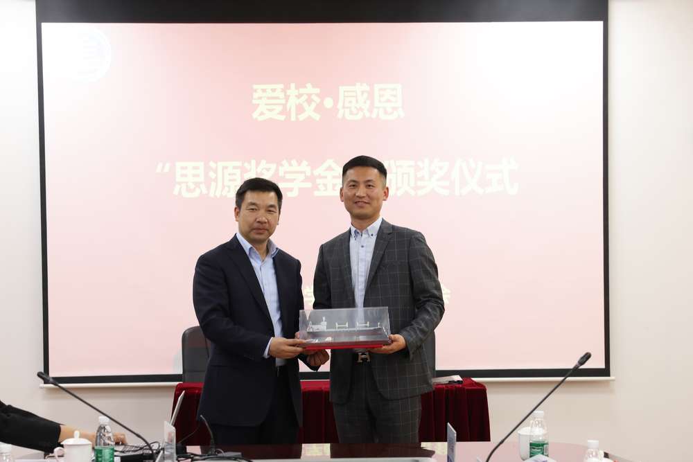 校党委副书记、副校长李志鹏为王伟校友赠送纪念品